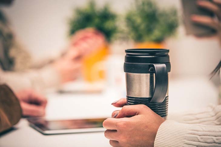Mujer sosteniendo un termo