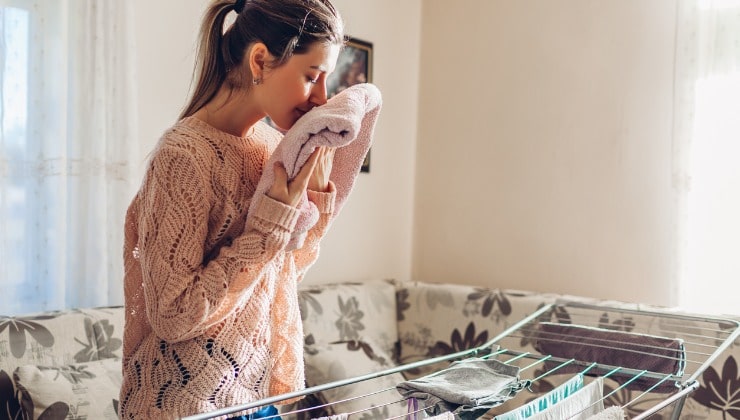 Mulher sente cheiro de roupas perfumadas