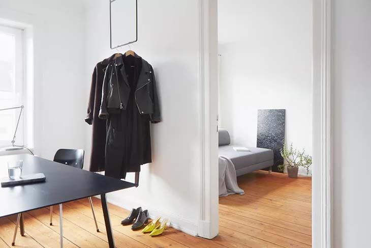 21 Ideen zum Aufbewahren von Kleidung, wenn Sie keinen Platz im Schrank haben 5 Kleidung, die neben einem Schreibtisch ausgestellt ist