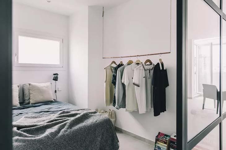 21 Ideen zum Aufbewahren von Kleidung, wenn Sie keinen Platz im Schrank haben 8 Lange Stange, die mit Kleidung von der Decke hängt