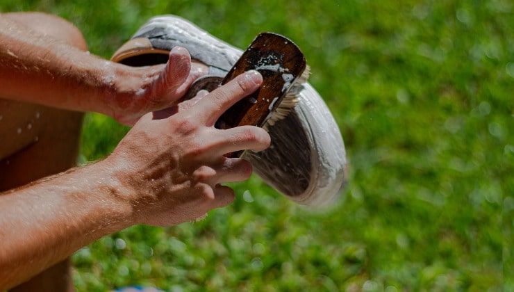 Junger Mann wäscht seine Turnschuhe