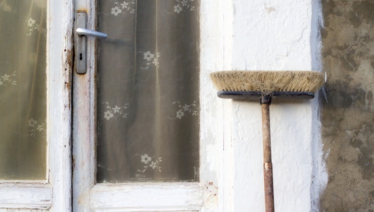 Alter und ramponierter Besen an der Wand