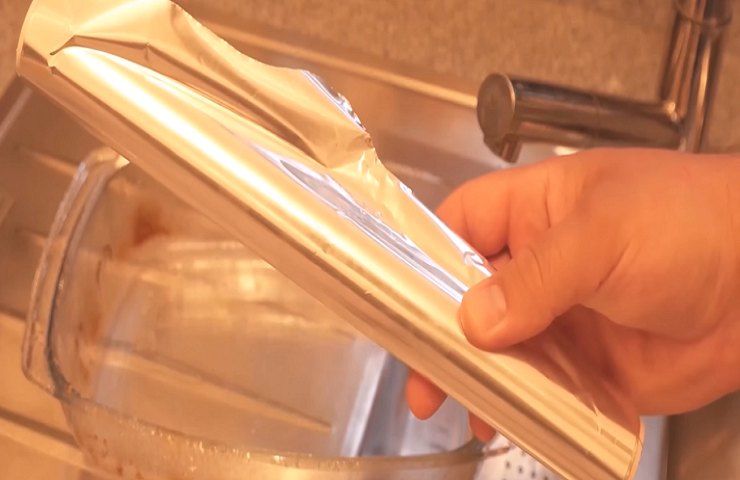 Schmutzige Auflaufform und Aluminiumfolienröhre