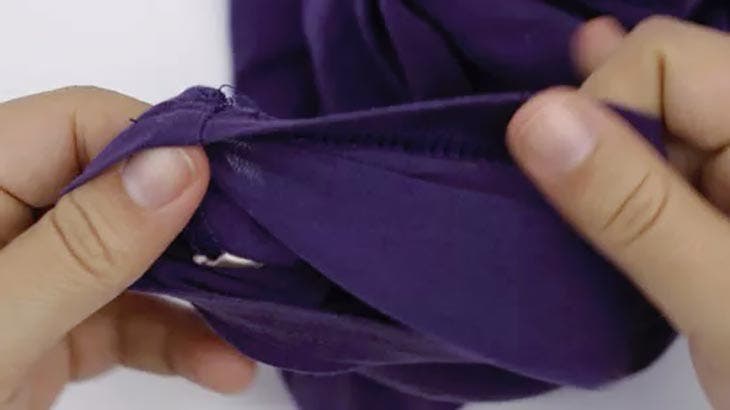 Nähen Sie das Kleidungsstück erneut mit einem Faden und einer Nadel zusammen, um es vollständig zu schließen