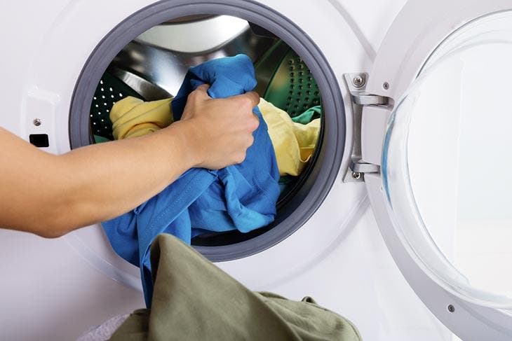 Kleidung in die Waschmaschine geben