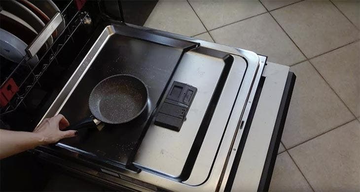 Stellen Sie die Pfanne in die Tür der Waschmaschine