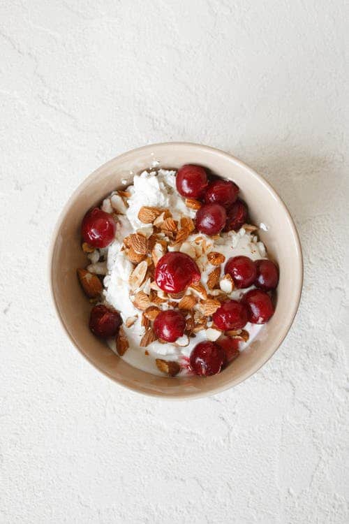Red and White Round Fruit in White Ceramic Bowl