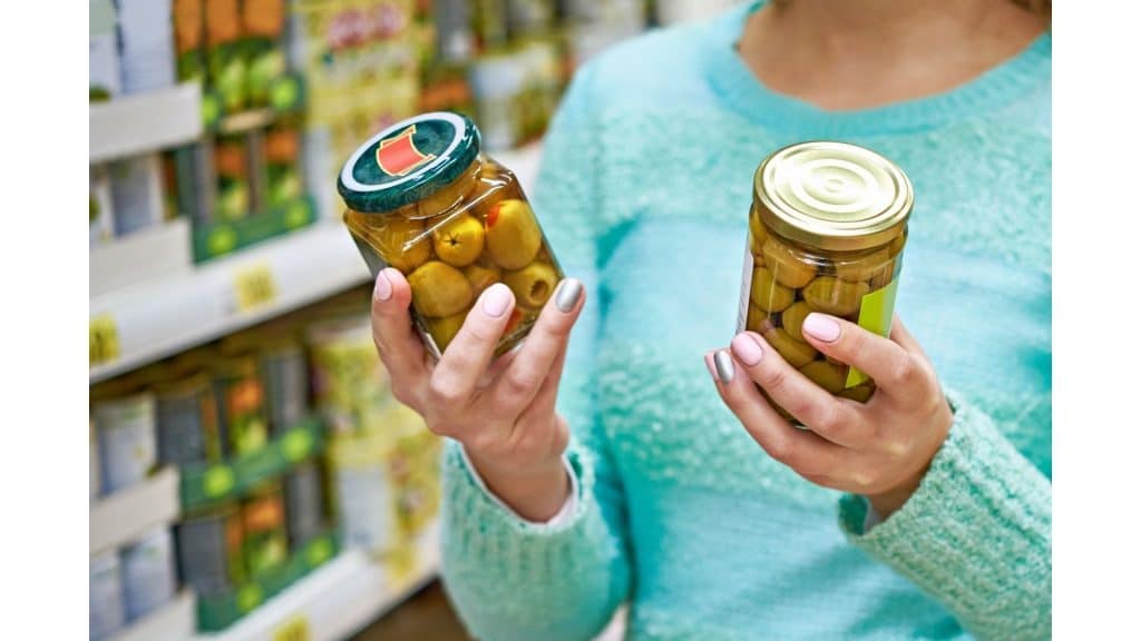 woman holding canned olives 