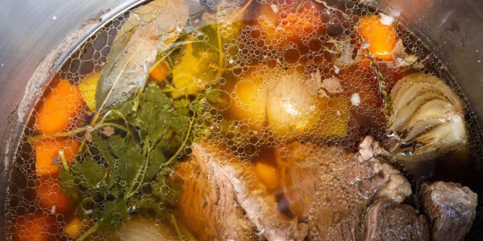 “Wie bereitet man eine herzhafte Rindfleischsuppe mit Beinscheibe, Markknochen, Gemüse und Leberknödel zu?”