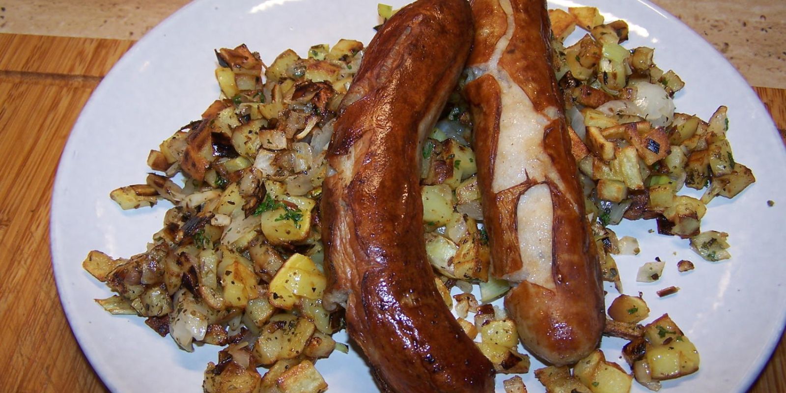 Bratwurst, Porreegemüse, neue Kartoffeln mit Bratfett