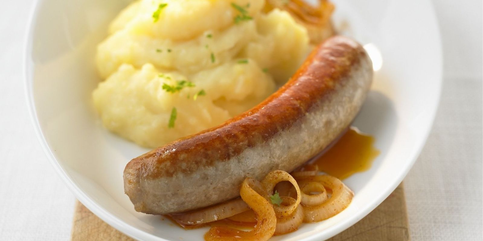 Bratwurst mit Porreegemüse und neuen Kartoffeln in Bratfett
