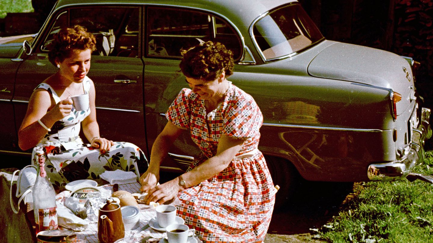 Vacation photo on the way south: mother and daughter having a picnic next to their private car in Merano.