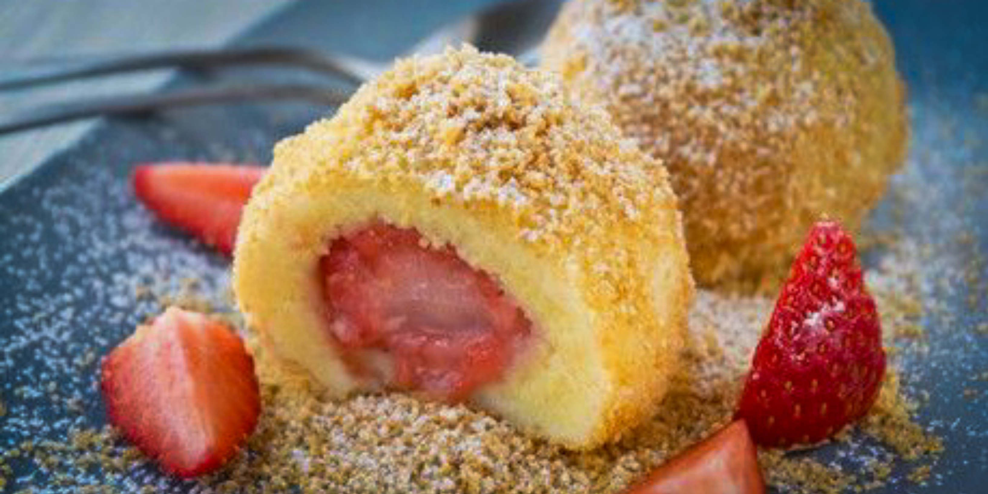 Erdbeerknödel mit Quarkteig, mit saurer Sahne serviert