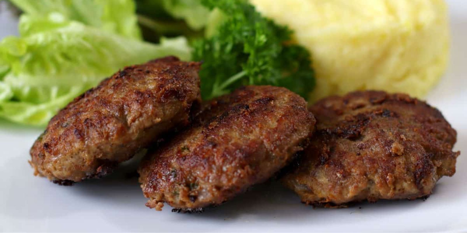 Fleischpflanzerl mit Kartoffelpüree und Gurkensalat