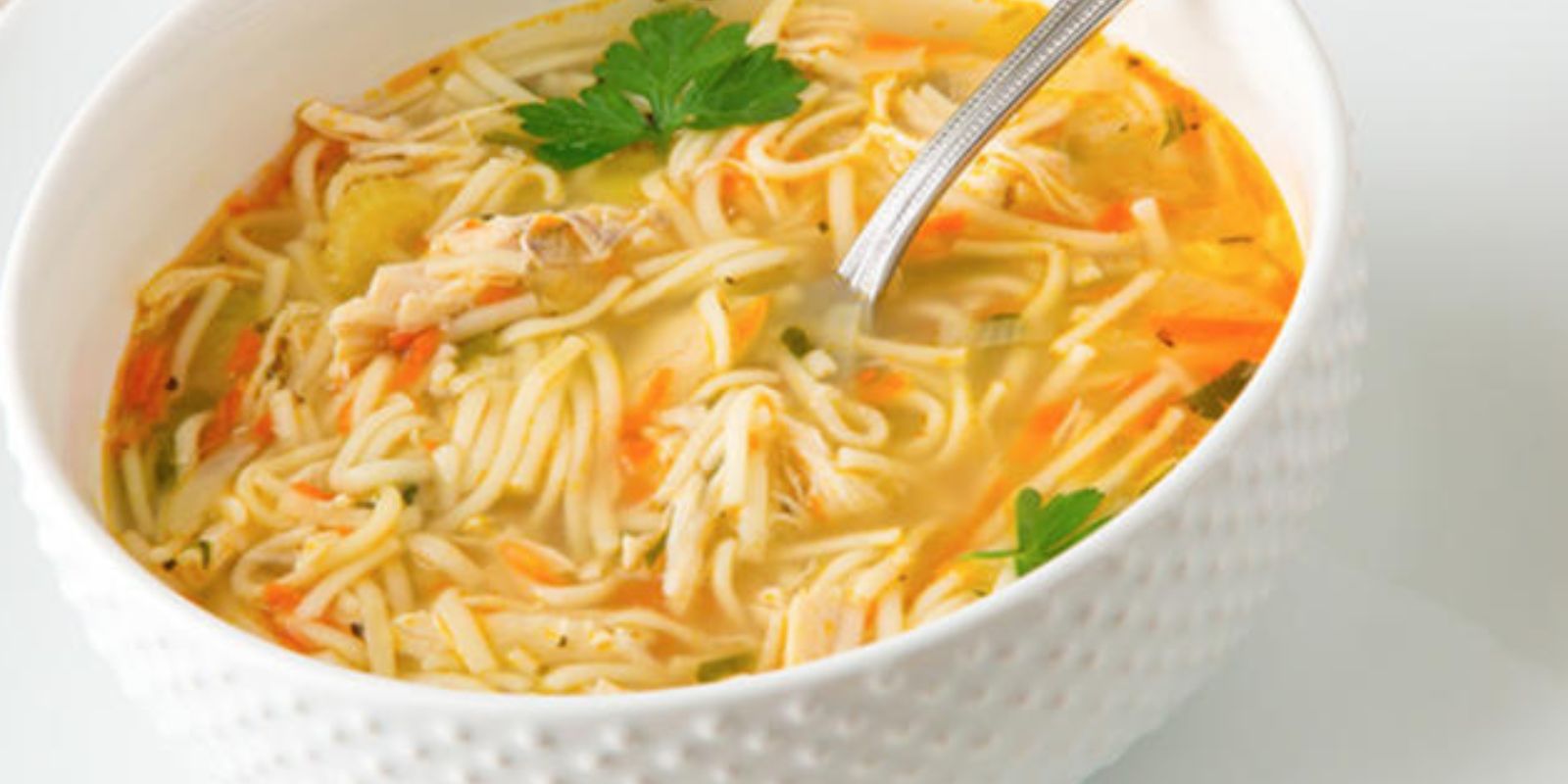 Hühnerbrühe mit Nudel und Brötchen