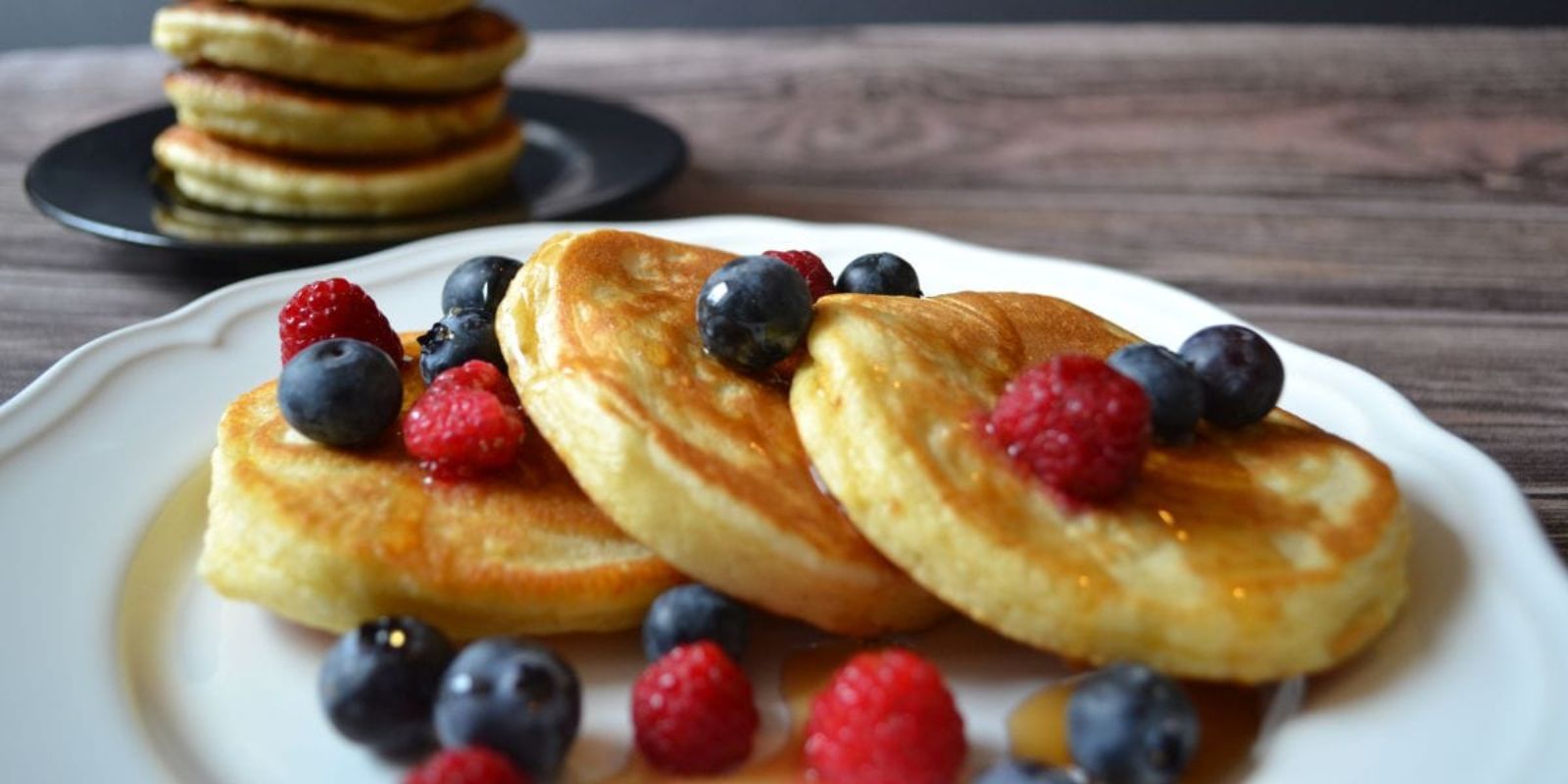 Klassische Pfannkuchen mit Ahornsirup und frischen Beeren