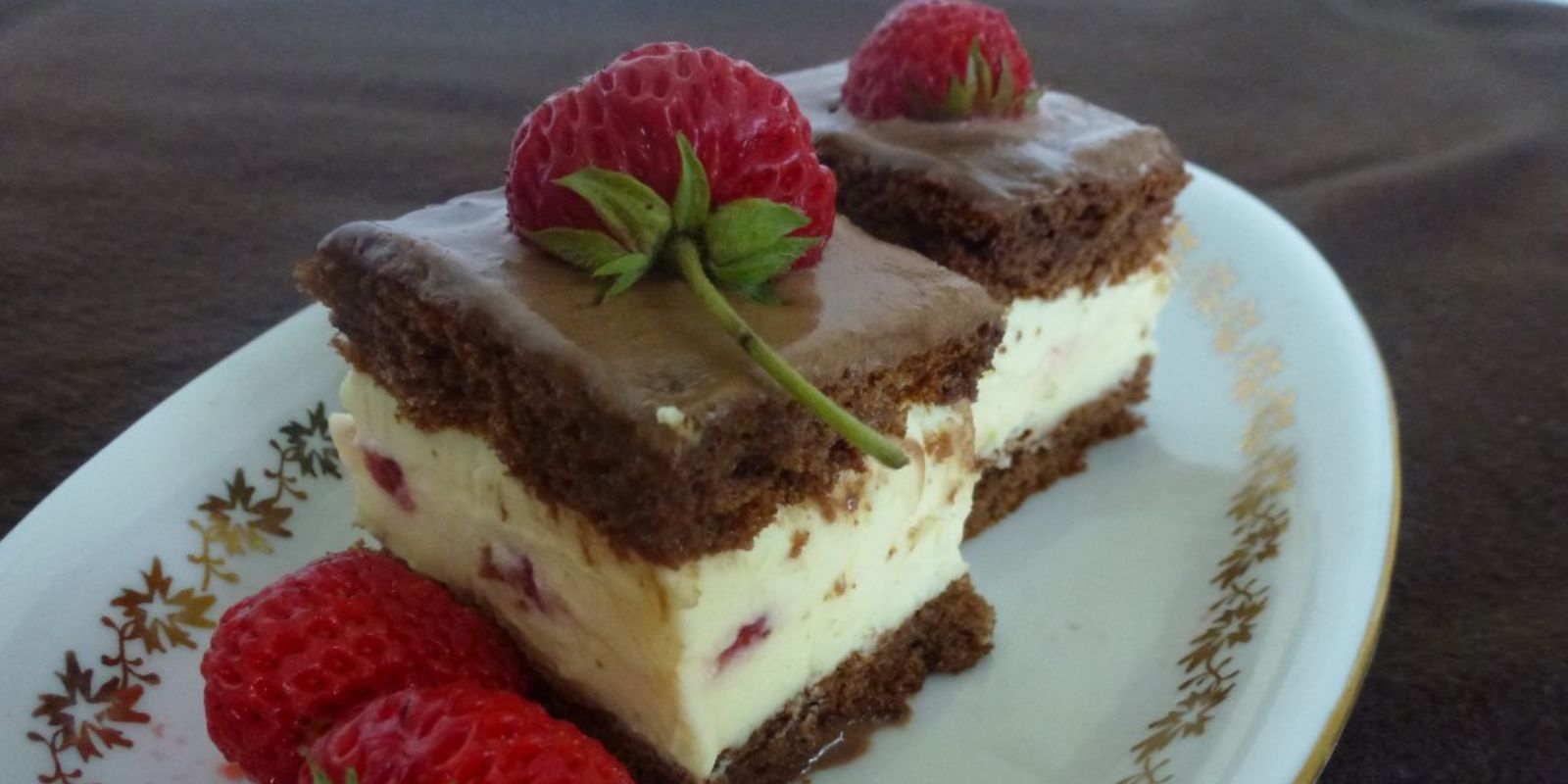 Köstlicher Schokokuchen mit Creme und Erdbeeren