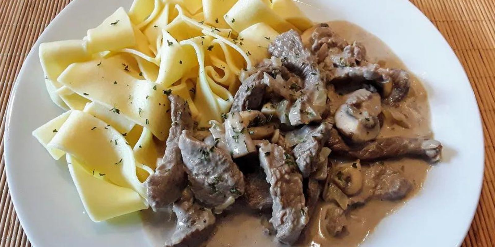 Pasta mit Champignons mit Rinderfilet in einer Kräuterbutter Sahne Sauce dazu Salat und Kräuterbutter Baguette mit Käse