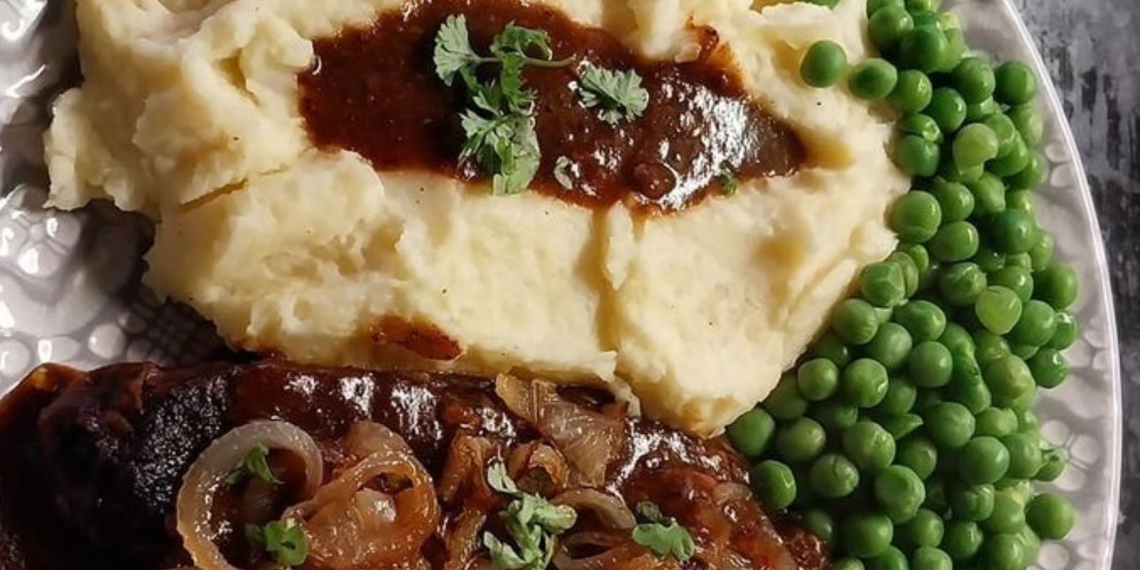 Schweineleber, Kartoffelbrei und Erbsen