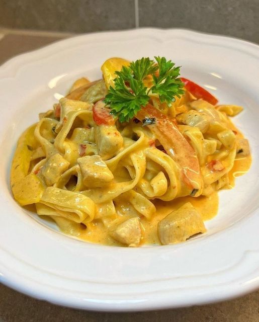 Cremige Hühnernudeln, gewürzt mit Paprika und Chili